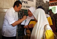 Bambang Soesatyo membubuhkan tandatangan pada kaos yang dikenakan saksi Tempat Pemungutan Suara (TPS) Golkar. (Hedi).