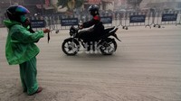 Seorang menjajakan masker di tengah hujan abu di Solo. Selama seharian matahari tak menampakkan diri di Solo.
