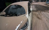 Sebuah mobil diparkir di pinggir jalan di Solo. Hingga siang hujan abu masih terkadi meskipun jauh lebih tipis dibanding pada dinihari.