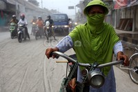 Seorang warga menuntun sepedanya di jalanan yang tertutup abu Kelud.