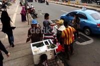 Sejumlah pedagang berjualan di pinggir jalur lambat Jenderal Sudirman.