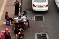 Seorang pedagang menunggu calon pembeli di pinggir Jalan Jenderal Sudirman.