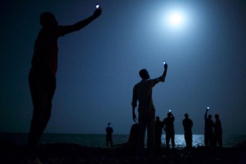     Ini adalah foto terbaik World Press Photo of the Year karya John Stanmeyer, fotografer Amerika Serikat. Foto dramatis ini menampilkan para migran di Djibouti sedang mencari sinyal ponsel.