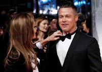 Jolie nampak merapikan dasi kupu-kupu Brad Pitt. REUTERS/Suzanne Plunkett.