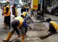 Pegawai Kimpraswil Kota Yogyakarta membersihkan material abu Kelud di sepanjang Jl Urip Sumoharjo.