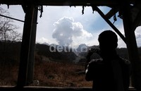Seorang warga mengabadikan puncak gunung Kelud yang masih mengeluarkan abu vulkanik.