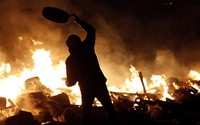 Seorang pendemo membakar ban bekas di depan Independence Square, Kiev. Reuters/Vasily Fedosenko.
