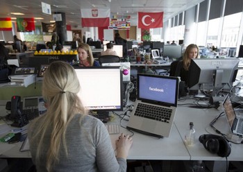 Salah seorang pekerja Facebook sibuk bekerja dengan laptopnya. (kredit foto: getty images)