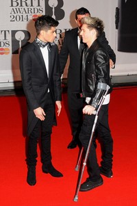 Niall menggunakan tongkat di red carpet. Anthony Harvey/Getty Images.