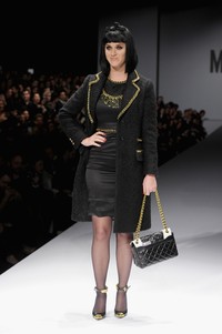 Pelantun 'Dark Horse' itu tampil dalam balutan dress satin hitam dengan luaran coat hitam dengan hiasan emas dari Jeremy Scott. Jacopo Raule/Getty Images.