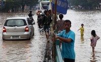Kendaraan bermotor melintasi di Jalan KH Abdullah Syafei, Tebet, Jakarta Selatan, yang tergenang banjir setinggi 30 - 40 centimeter, Minggu (23/02/2014).
