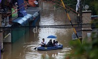Warga dievakuasi dengan perahu karet.