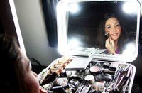 Maia memoleskan make-up di wajahnya.