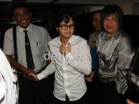 Dul hadir mengenakan kemeja putih berlengan panjang dan kacamata.