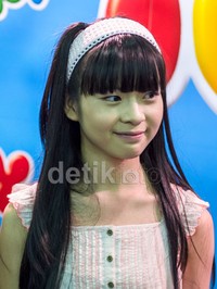 Yupi tampil manis dengan busana putih.