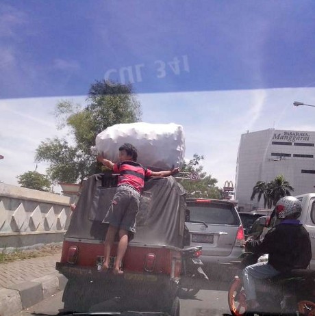 Beginilah Cara Ekstrem Menaiki Bajaj Sambil Bawa Karung