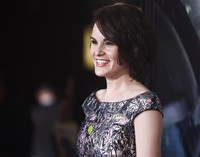 Tiba di lokasi acara, Michelle Dockery nampak berseri-seri. REUTERS/Fred Prouser.