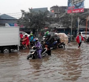 Sejumlah Kendaraan Terperosok Lubang Tertutup Banjir di Jl Gunung Sahari