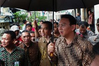 Basuki Tjahaja Purnama (Ahok) memayungi Joko Widodo (Jokowi) saat meninjau Kampung Deret di Petogogan.