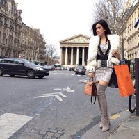     Syahrini yang mengenakan blazer dan dress bermotif kulit ular, sepatu boots dan jaket bulu eksis berpose dengan kantong belanjaan oranye dari Hermes. (Instagram)
