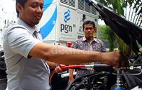 Seorang petugas mengisi bahan bakar gas pada acara seminar, pameran, workshop '8th Natural Gas Vehicles & Infrastruktur Indonesia Forum and Exhibition 2014'.
