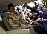 Azwar Abubakar sempat melempar senyuman dari dalam mobil sebelum meninggalkan gedung KPK. Lamhot Aritonang/detikFoto.