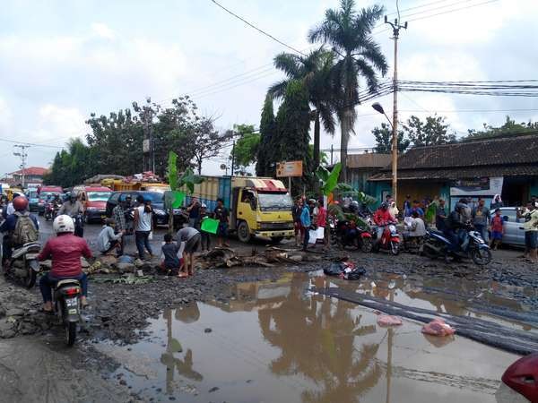 Jalan Rusak Mirip Empang, Warga Serang Blokir Jalan dengan Tanam Pisang