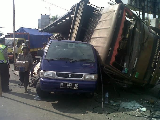Truk Pengangkut Air Mineral Terguling Timpa 1 Mobil dan 2 Motor di Semarang