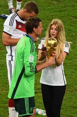 Roman Weidenfeller menunjukkan trofi Piala Dunia kepada sang pacar, Lisa Rossenbach. Chistophe Simon/AFP/detikFoto.