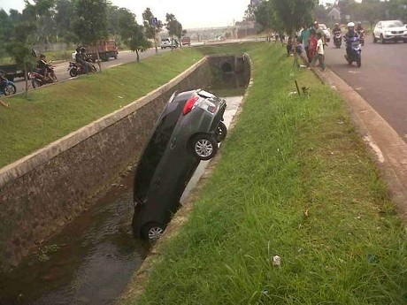 Lupa Pasang Rem Tangan, Mobil MPV Nyelonong Masuk Parit di Bintaro