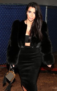 Tampil serba hitam lewat midriff dress dengan luaran mantel bulu, Kim nampak elegan. Christopher Polk/Getty Images/detikFoto.