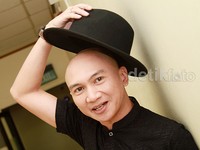 Anji menutupi kepala botaknya dengan topi hitam. Pool/Gus Mun/detikFoto.