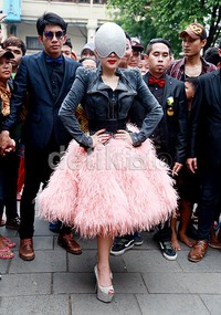 Syahrini tampil nyentrik mengenakan jaket hitam dengan hiasan stud, rok bulu pink dan heels silver.
