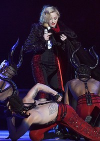 Madonna tampak berusaha melepaskan jubahnya. REUTERS/Toby Melville/detikFoto.