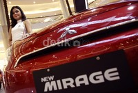 Seorang model berpose dengan Mitsubishi New Mirage.