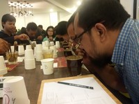 Para peserta sedang mencium aroma kopi yang sudah ditambahkan air panas.