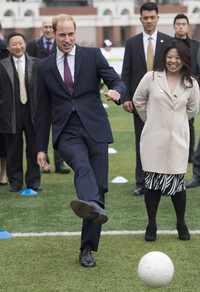 Pangeran William yang tampil necis mengenakan setelan jas biru gelap itu nampak santai saat menendang bola. Tim Rooke/Pool/Getty Images/detikFoto.
