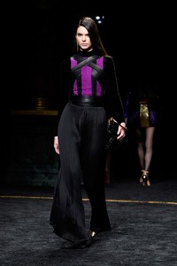 Dibalut jumpsuit hitam dengan nuansa ungu, model dengan tinggi badan 178 cm itu melangkah penuh percaya diri. Pascal Le Segretain/Getty Images/detikFoto.