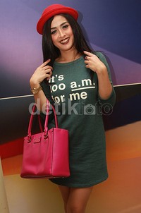 Topi merah dan tas pink melengkapi penampilannya. Pool/Gus Mun/detikFoto.