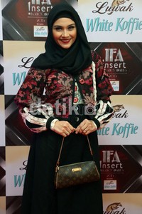 Zee Zee memadukan penampilannya dengan tas merk Louis Vuitton.