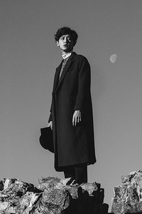 Chanyeol berdiri di puncak sebuah bukit berbatu. (SMTOWN)