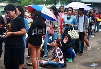 Beberapa calon penonton menggunakan payung untuk menghindari terik matahari.