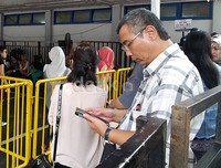 Ini tukerin tiketnya anak. Dia lagi sekolah soalnya. Jadi bawa surat kuasa segala macem, ujar seorang bapak yang mengantre untuk menukarkan voucher tiket anaknya.