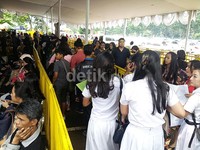 Lewat tengah hari, calon penonton berseragam SMA mulai meramaikan lokasi penukaran tiket konser One Diraction.