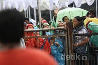 Padatnya antrean dan hujan deras membuat suasana semakin ricuh.