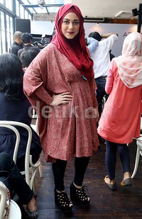 Istri Dennis 'Lyla' itu bergaya dengan hijab merah, blus kaftan bernuansa merah, celana hitam dan sepatu hitam.