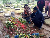 Para pelayat tampak mendoakan Olga di sisi pusara Olga.