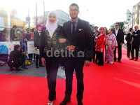 Reva tampil berhijab putih dipadu blazer bordir dan celana panjang berwarna hitam.