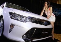 Seorang model berpose dengan New Camry.