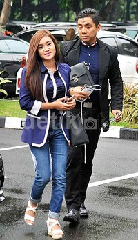     Sang pedangdut terlihat mengenakan blazer berwarna biru dengan celana denim berkelir senada. Pool/Noel/detikFoto.